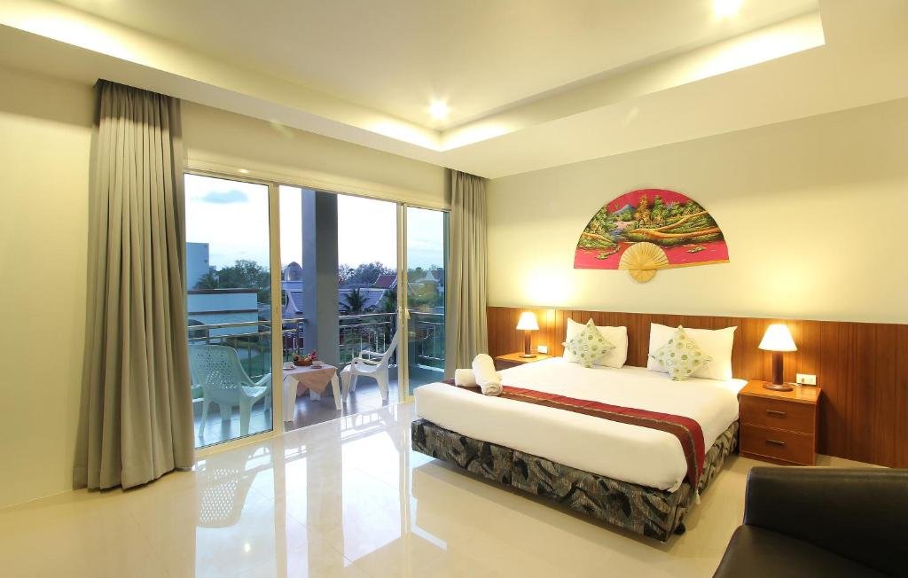 Cette chambre d'hôtel comprend un lit et un balcon. dans l'établissement Choophorn House SHA, à Kata Beach
