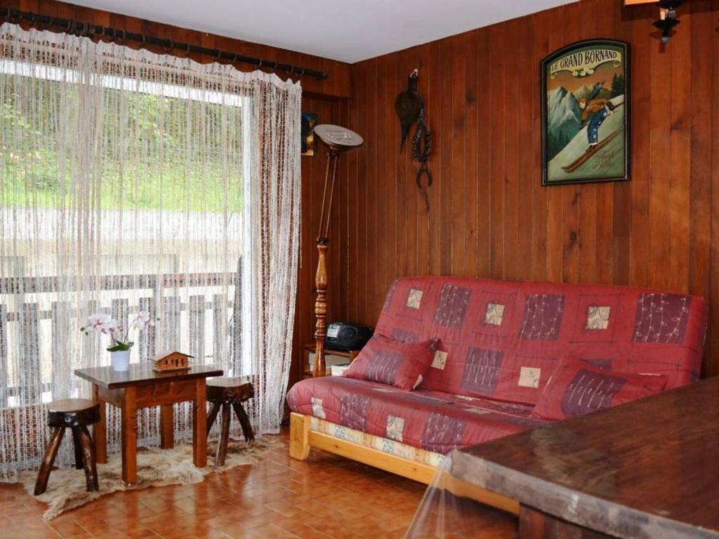 uma sala de estar com um sofá vermelho e uma janela em Studio Le Grand-Bornand, 1 pièce, 4 personnes - FR-1-241-227 em Le Grand-Bornand