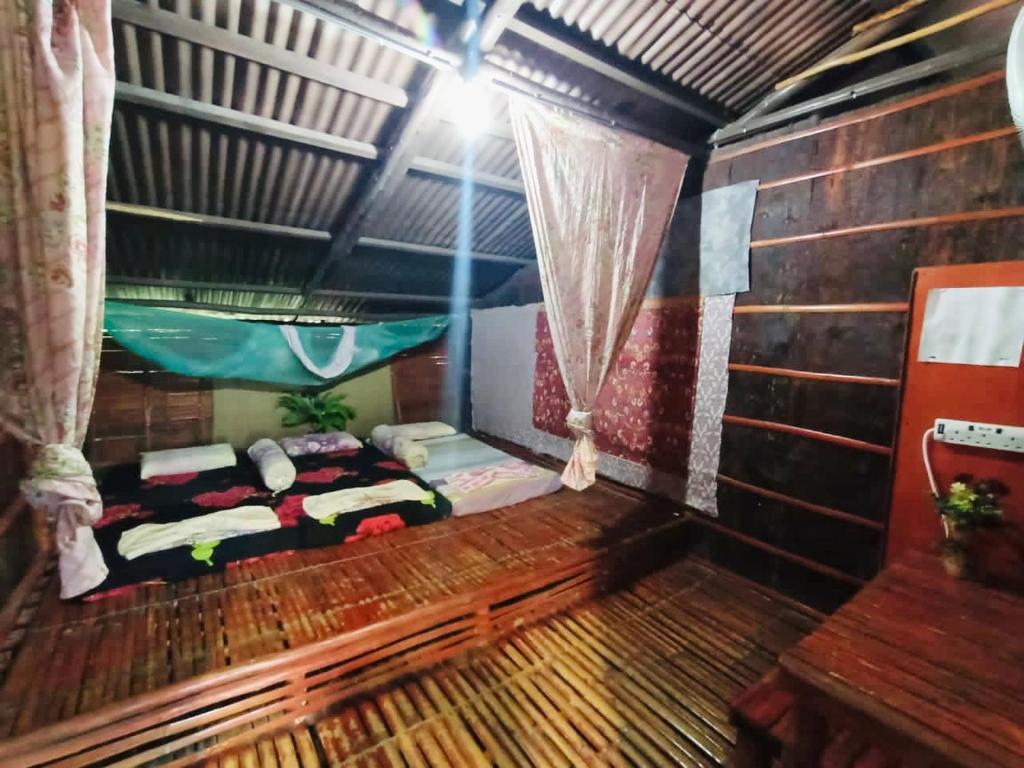 a room with two beds and a hammock in it at Dragon Pearl Beach Resort in Kota Belud