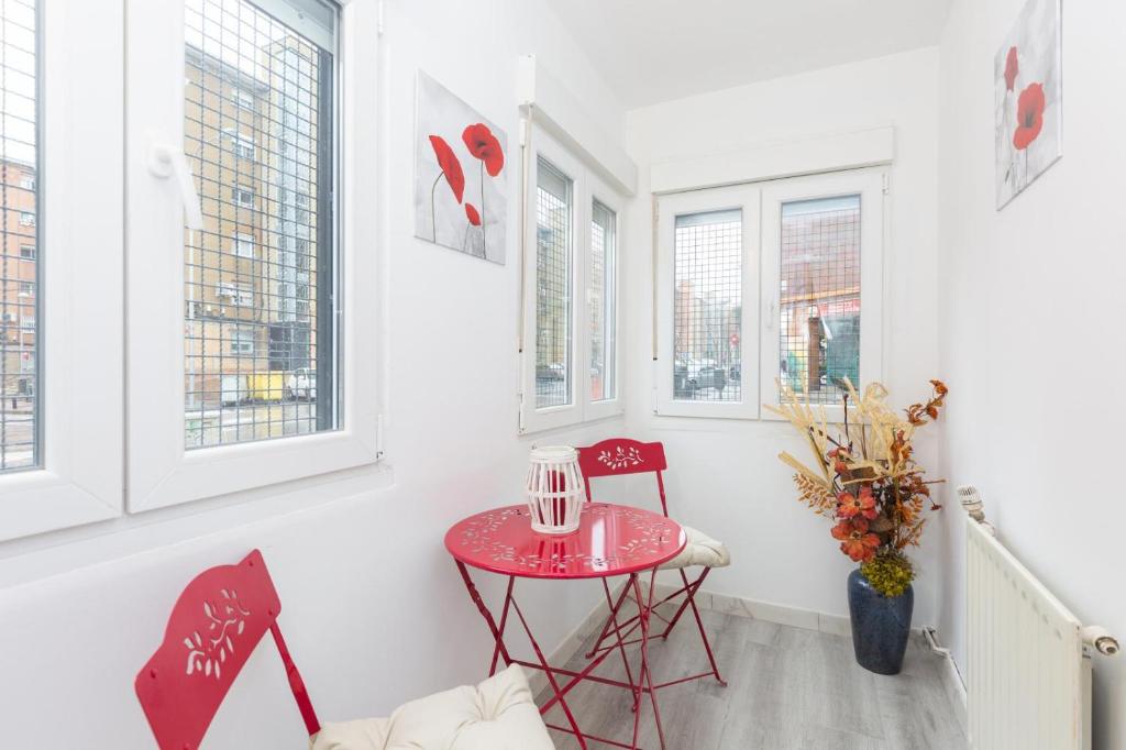 - une petite table rouge dans une chambre avec fenêtres dans l'établissement Apartamento Casa de Campo, à Madrid