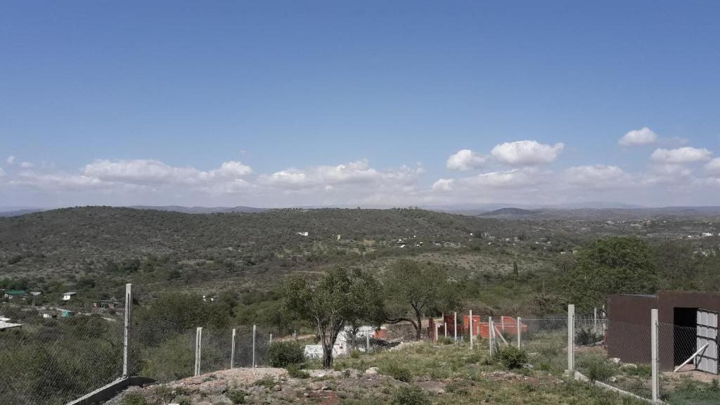 a view of a hill with trees and a city at Cabañas Teodoro in Tanti