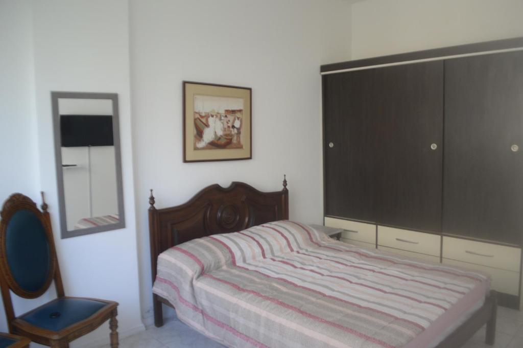 1 dormitorio con 1 cama, vestidor y silla en Conforto de copa na quadra da praia, en Río de Janeiro