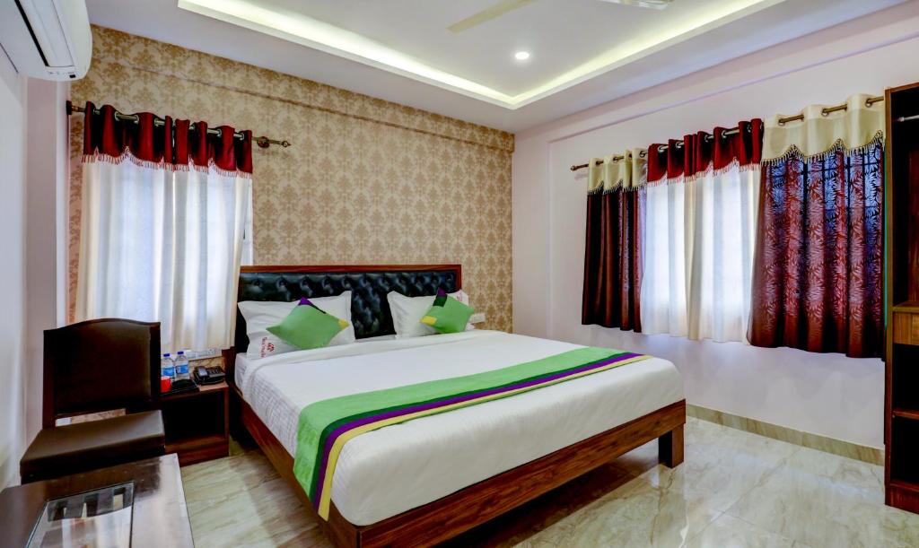 a bedroom with a large bed and some windows at Treebo Trend Three Street Inn in Bangalore