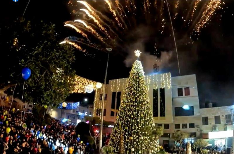 a christmas tree in front of a crowd of people at Bethlehem home in Bethlehem