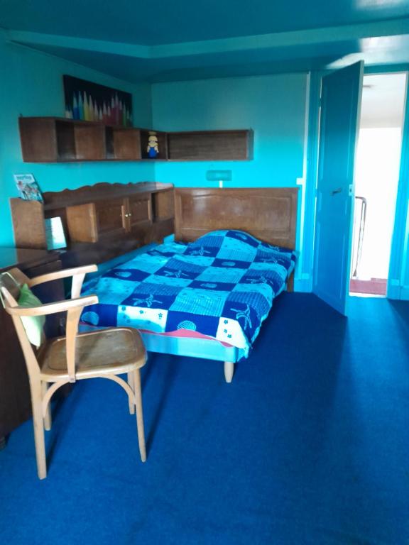 1 dormitorio con 1 cama y 1 silla en chambre d'hôtes de Flo, en Brosses