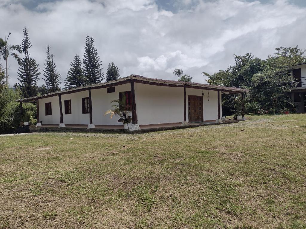 a small white house with a large yard at Ecopolis casa de campo in Papagalleros