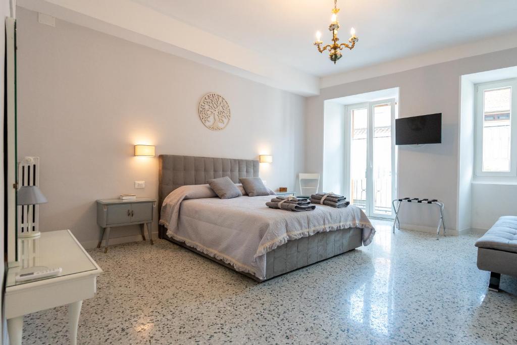 a white bedroom with a bed and a chandelier at B & B L'ABBRACCIO in Agnone