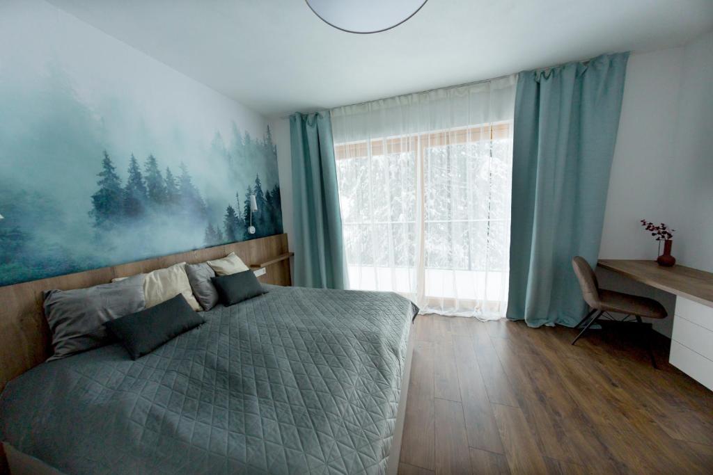 - une chambre avec un lit et une grande fenêtre dans l'établissement Apartmán Snow, à Oravská Lesná