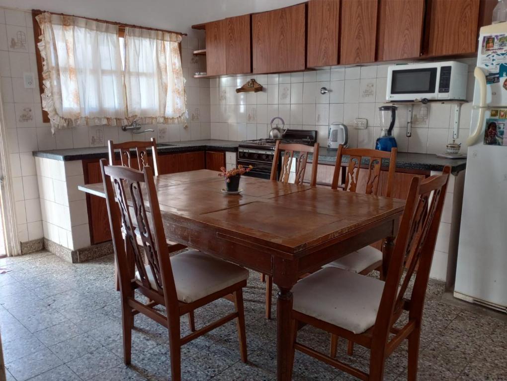 cocina con mesa de madera y sillas en Casa familiar de verano San Carlos en Mar del Plata