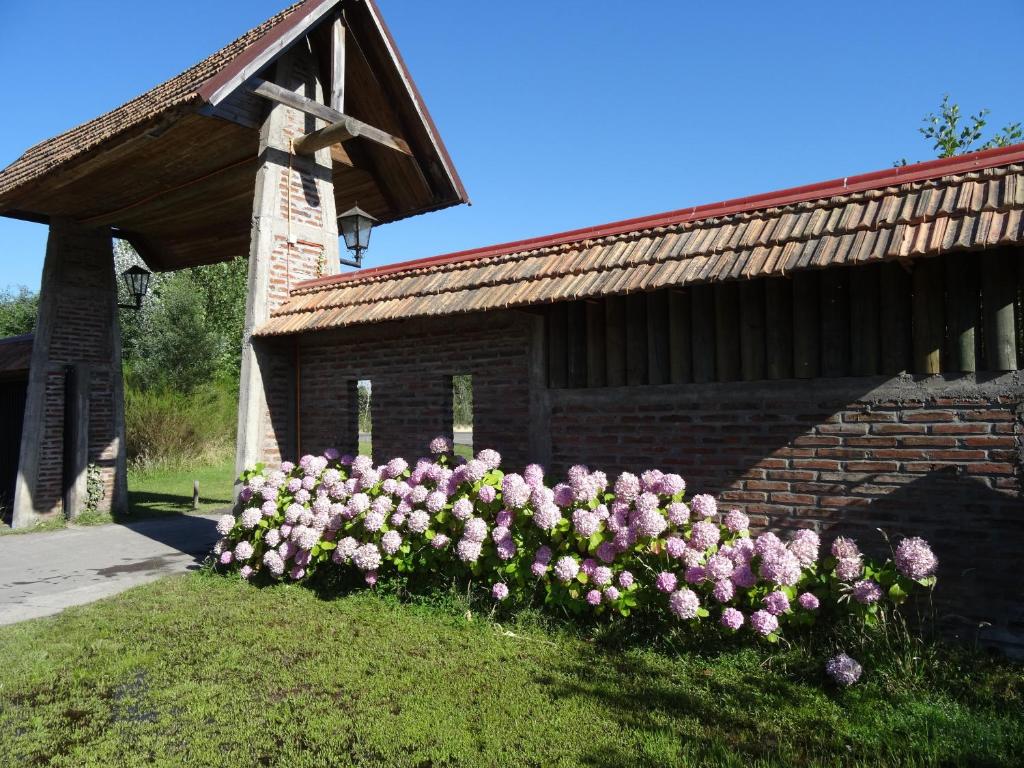 un ramo de flores rosas delante de un edificio en Cabañas Parque Salto del Laja en El Manzano