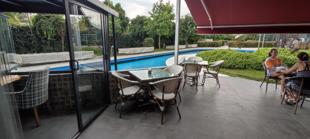 two women sitting on the patio of a house with a pool at Tips For istanbul in Istanbul