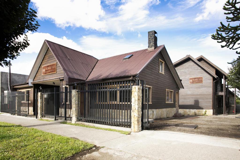 une maison noire avec un toit en métal dans l'établissement Rumbo Sur Apart Hotel, à Coyhaique