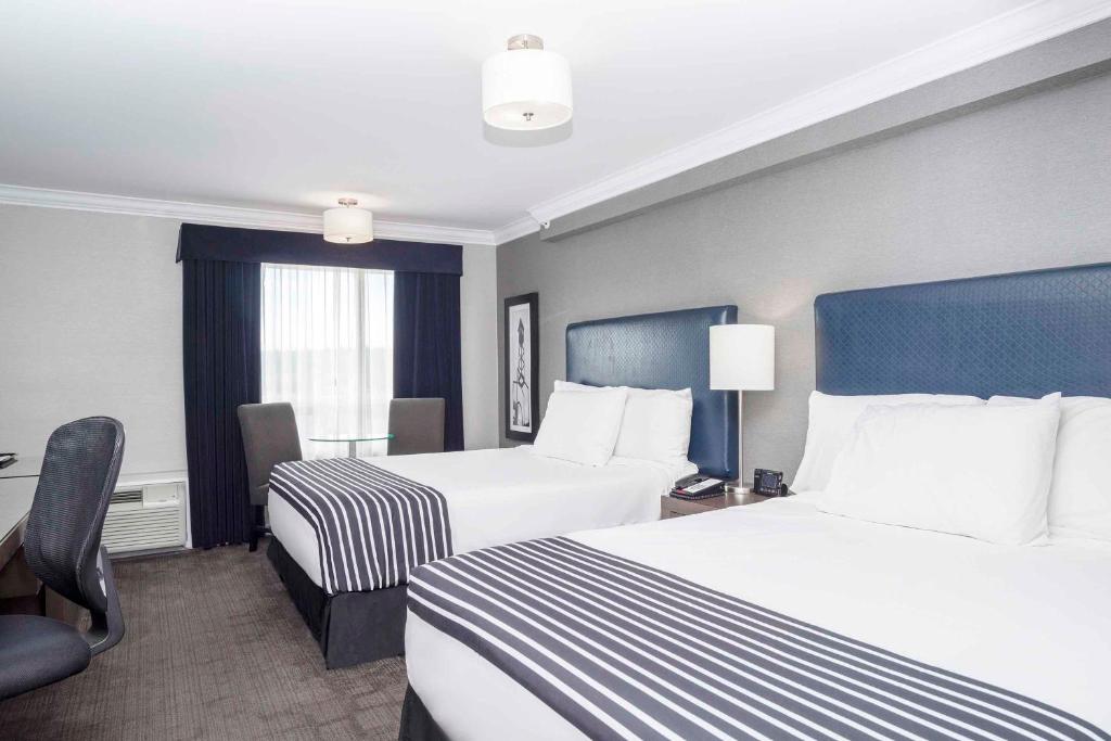 Postel nebo postele na pokoji v ubytování Sandman Signature Prince George Hotel