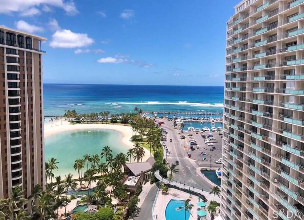 a view of the beach from the balcony of a resort at Ilikai Apt 1822 - Newly Renovated 2BR 2BA Modern Unit with Stunning Ocean & Harbor Views in Honolulu