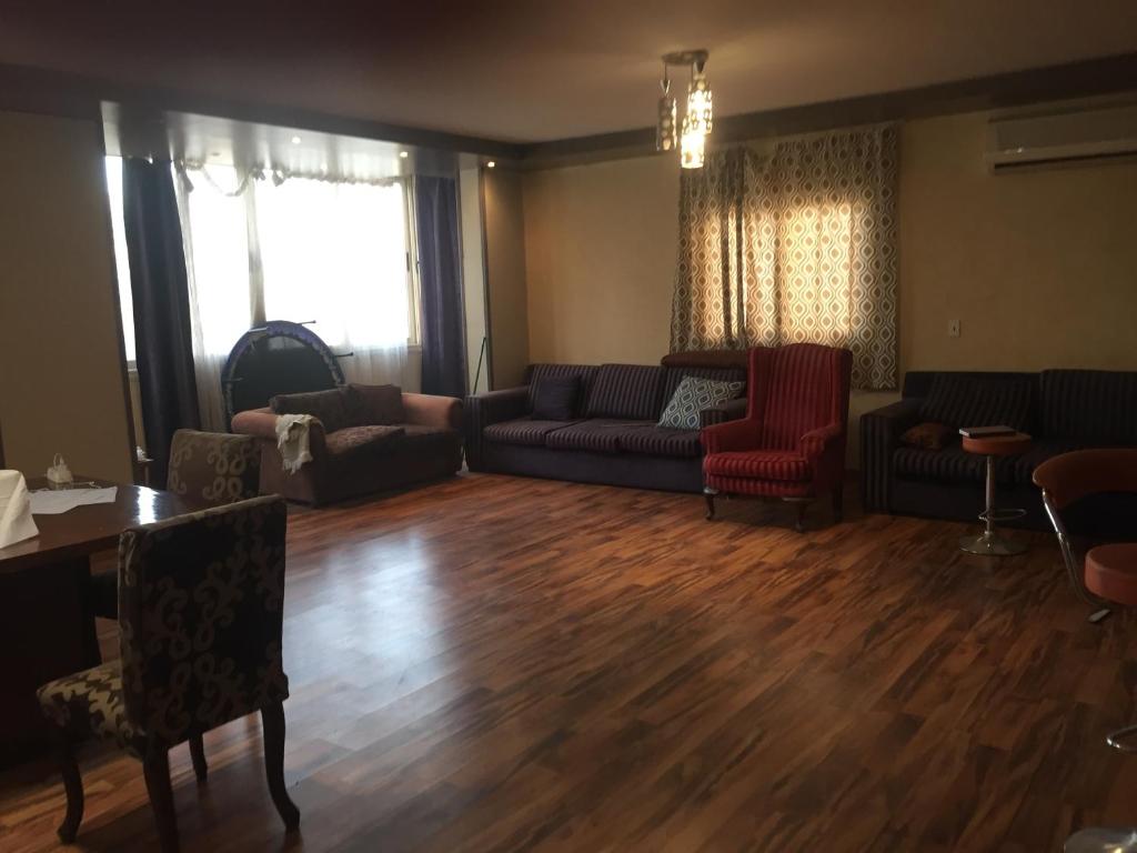 uma sala de estar com um sofá, cadeiras e uma mesa em Family residence in the best location no Cairo