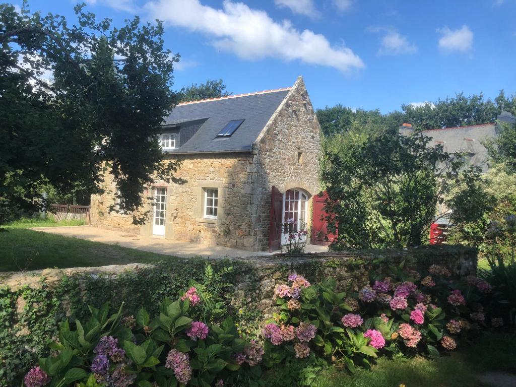 uma casa de pedra com flores em frente em Carnac: Maison chaleureuse, calme proche plages em Carnac