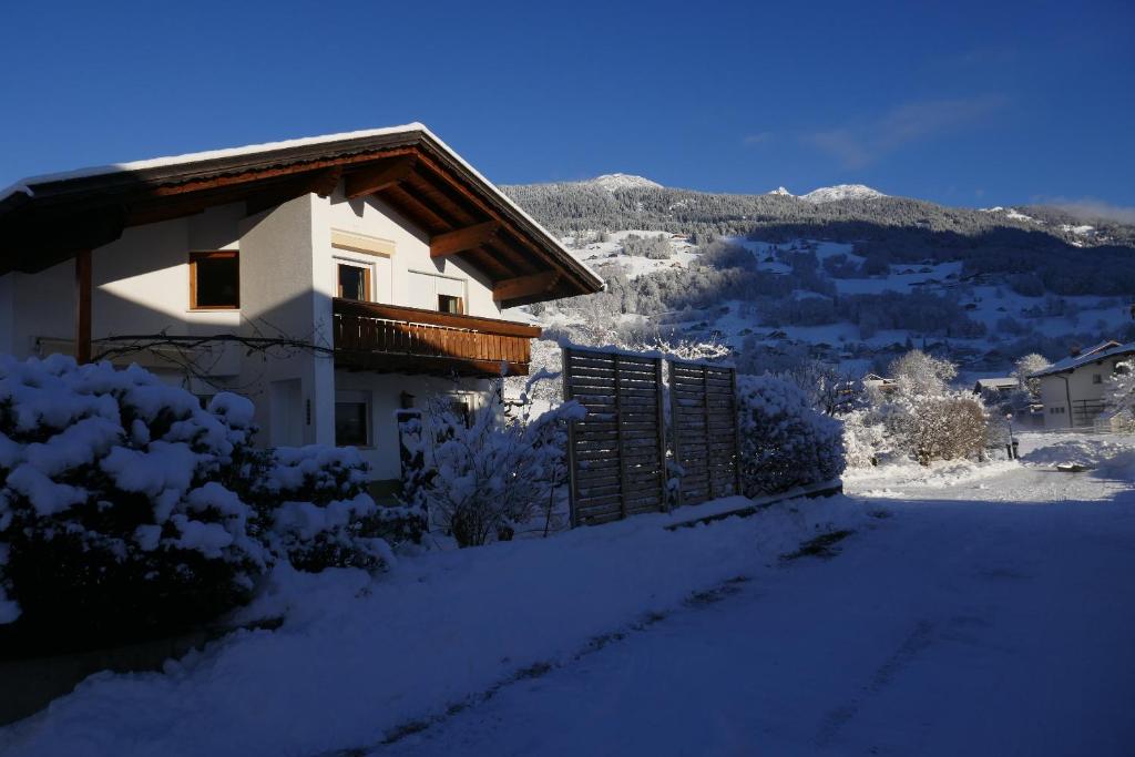 ein schneebedecktes Haus mit einem Berg im Hintergrund in der Unterkunft Apartment Fritsch in Schruns-Tschagguns