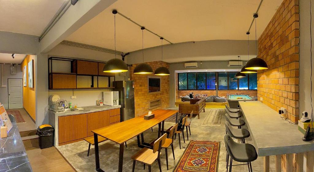 a kitchen and living room with a table and chairs at Arch Dormitorio Cenang in Pantai Cenang