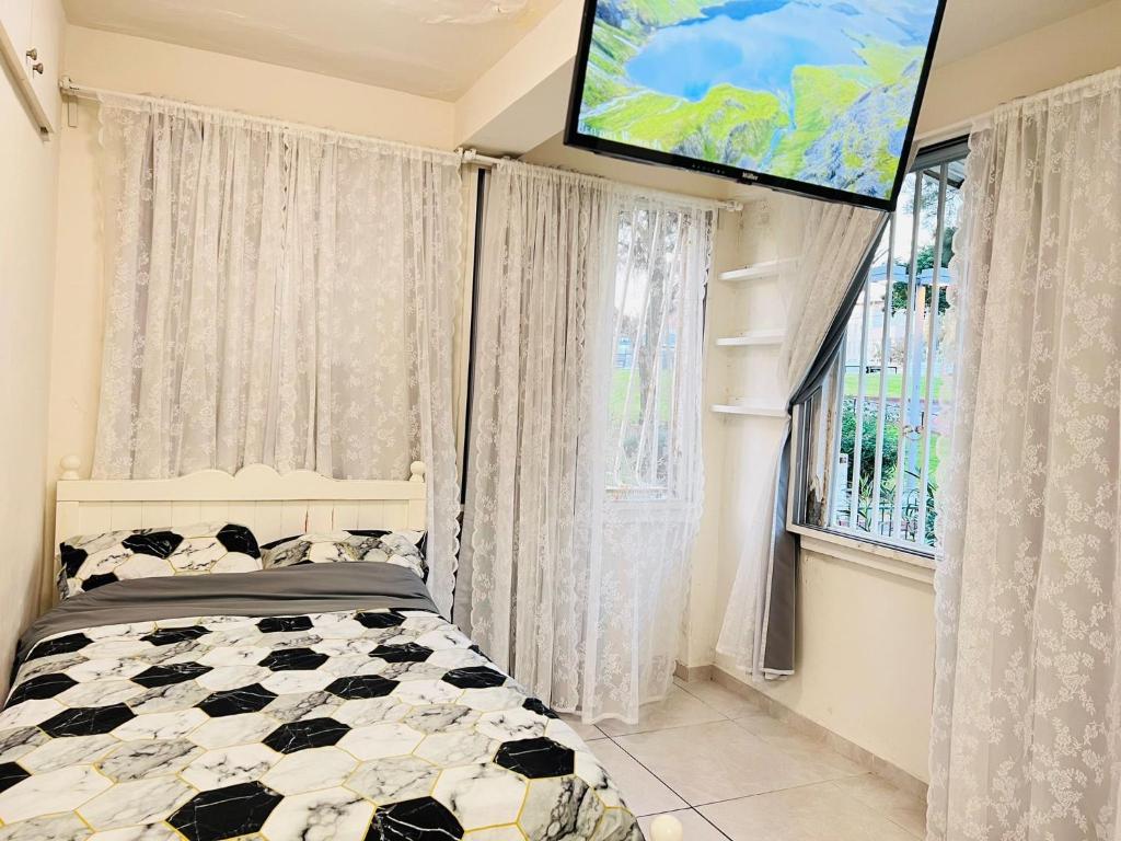 a bedroom with a bed and a flat screen tv at New - Luxury Studio 3 Minutes From Beach ! in Tel Aviv