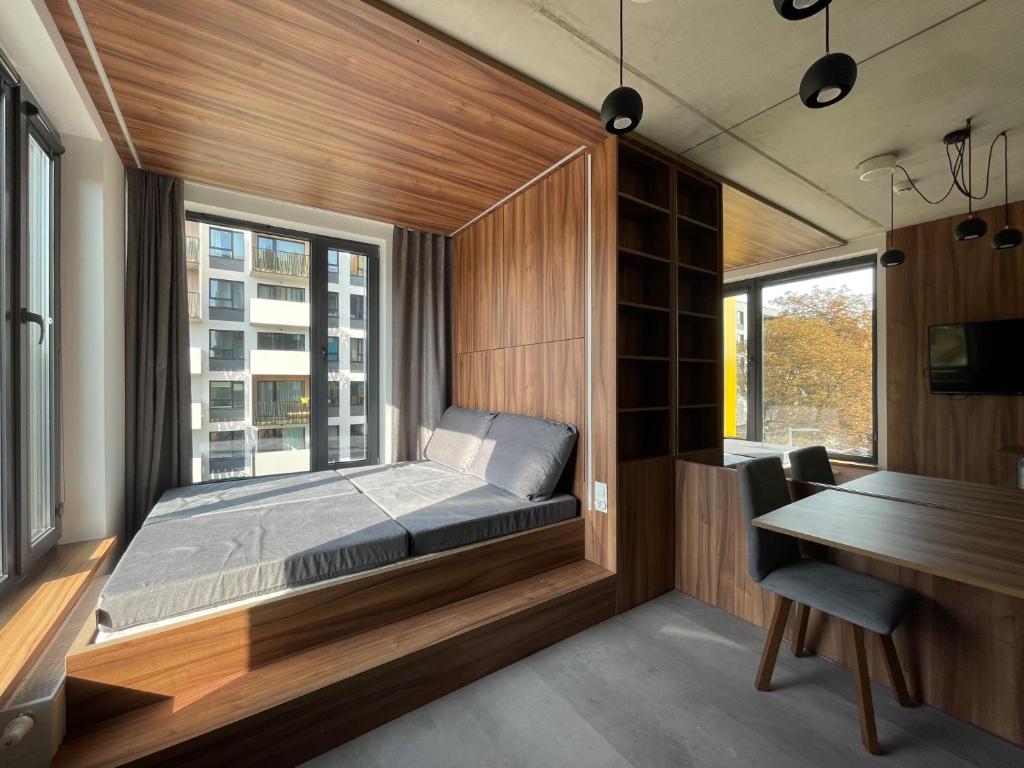 a bedroom with a bed and a desk and a window at Legnicka Business Apartments in Wrocław