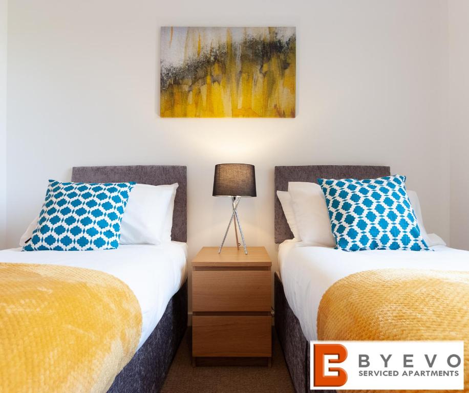 a bedroom with two beds and a painting on the wall at ByEvo 5 Brabloch - perfect for contractors - Close to GLA in Paisley