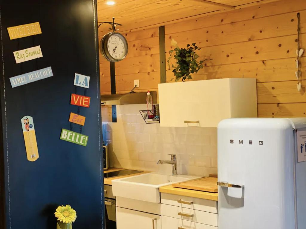 a kitchen with a sink and a clock on the wall at Studio Du Moulin in Saint-Laurent-dʼAndenay