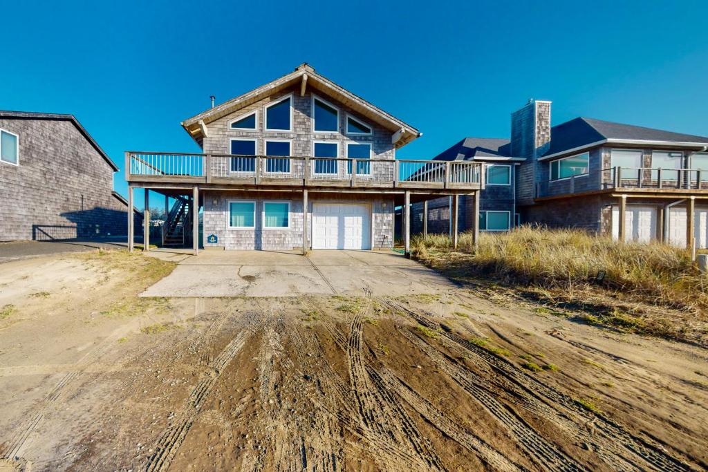 a house on the beach with a dirt road in front at The Kiwanda Surf House in Pacific City