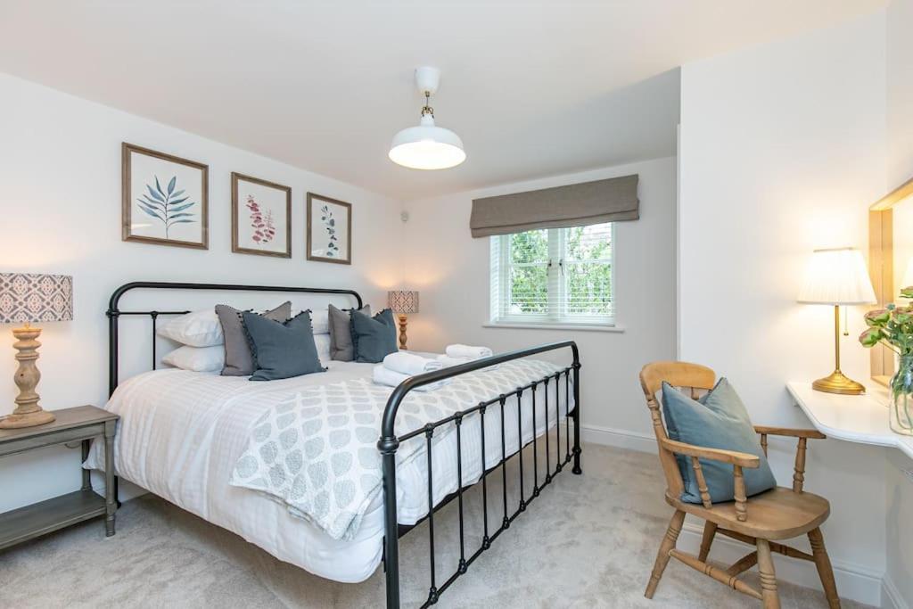 a bedroom with a bed and a desk and a chair at Oxfordshire Living - The Sunderland Apartment - Bladon in Bladon