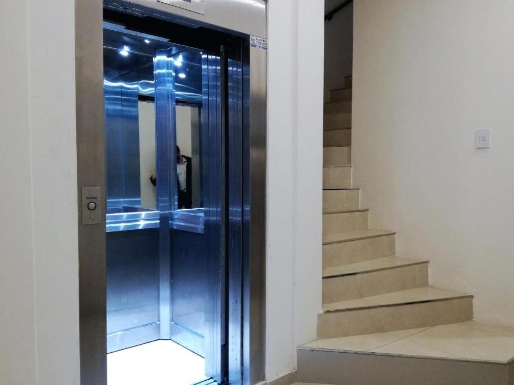 ascensor de cristal en un edificio con escalera en Apart del Centro 02 en Santa Fe