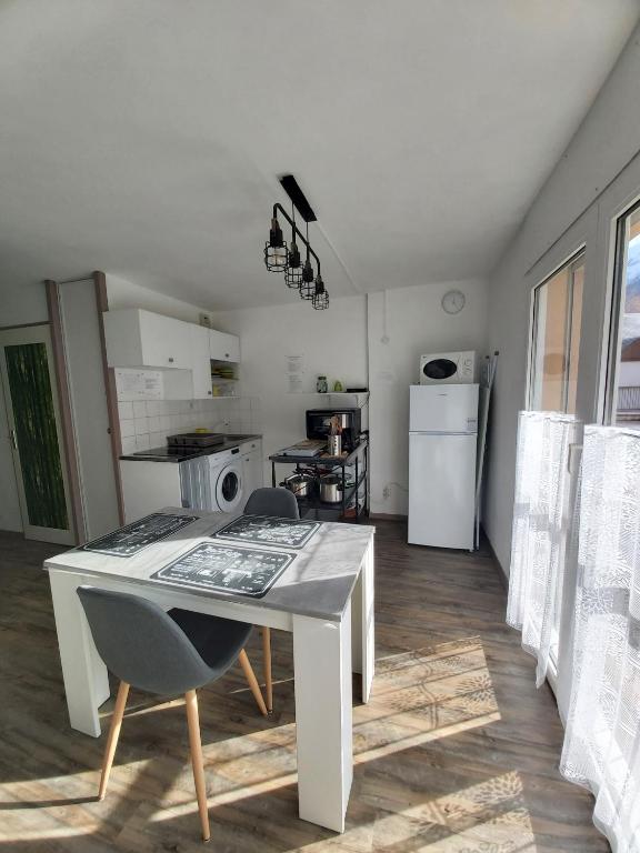 a small kitchen with a table and a refrigerator at Luz St Sauveur, Appartement 3 personnes, vue montagne, exposé sud, Résidence très calme in Luz-Saint-Sauveur