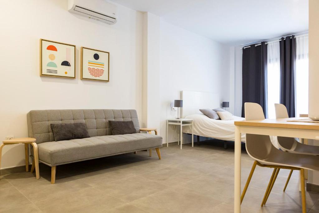 ein Wohnzimmer mit einem Sofa und einem Bett in der Unterkunft Apartamento Málaga Marmoles 2 in Málaga