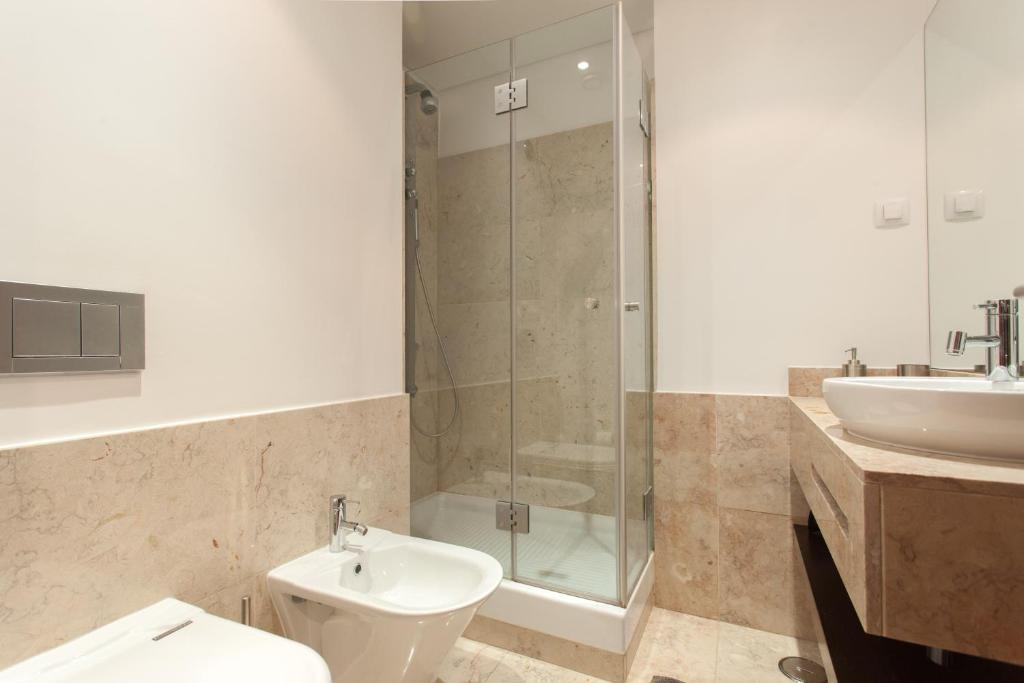 ein Bad mit einer Dusche, einem WC und einem Waschbecken in der Unterkunft FLH Expo Cozy Apartment in Lissabon