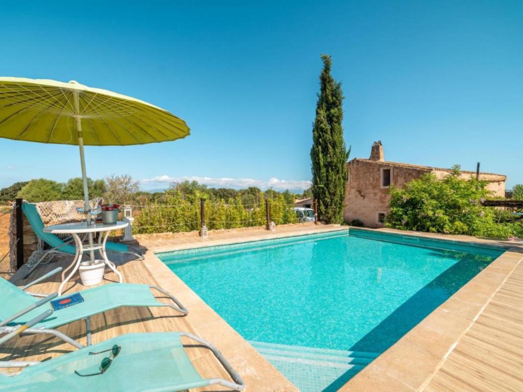 una piscina con mesa, sillas y sombrilla en Villa Can Lloret, en Algaida