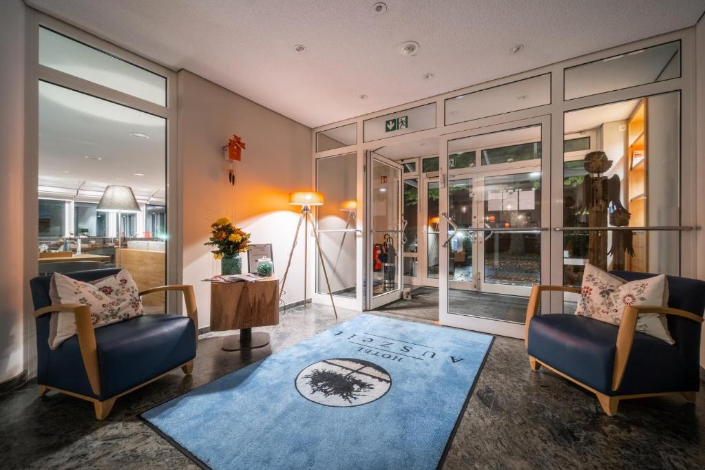 sala de estar con 2 sillas y alfombra azul en Auszeit Hotel Hamburg en Hamburgo