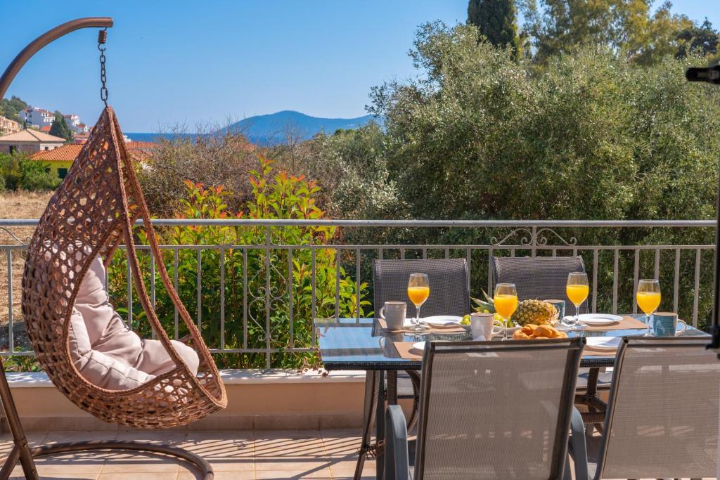 a patio with a table with wine glasses and a hammock at Family Villa Citrine Kefalonia - near Agia Efimia in Agia Effimia