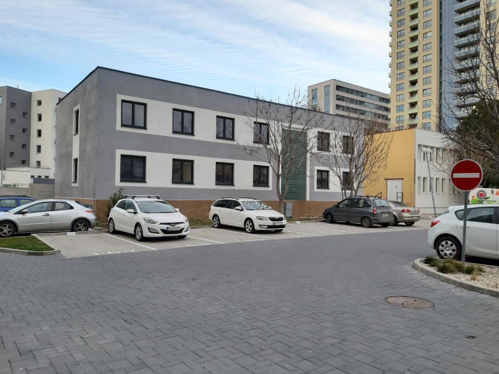 un estacionamiento con autos estacionados frente a un edificio en Living Bratislava Centrum &Mlynské Nivy& Bus station en Bratislava