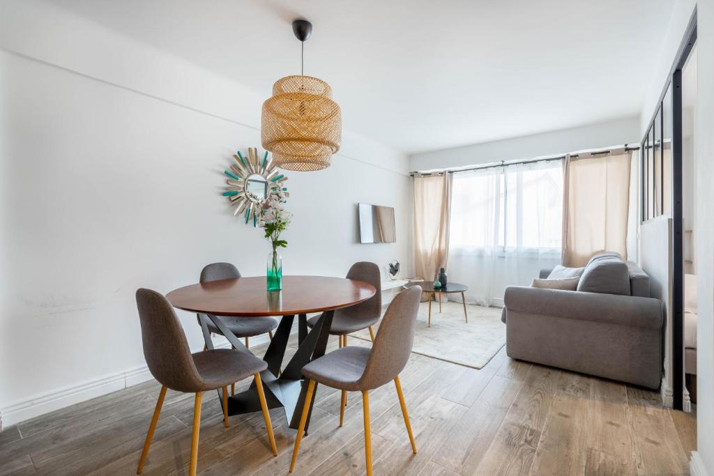 Agence des Résidences - Plein centre de Cannes في كان: غرفة معيشة مع طاولة وكراسي وأريكة
