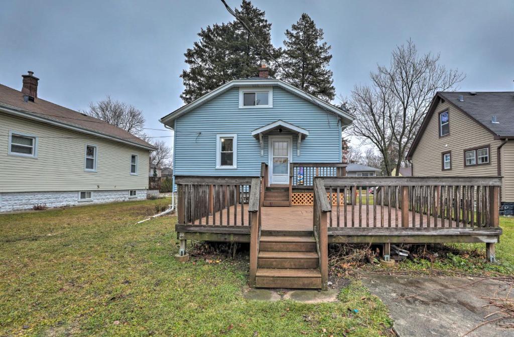 a blue house with a porch and a wooden bench at Cozy Westmont Home Walk to Metra Station! in Westmont