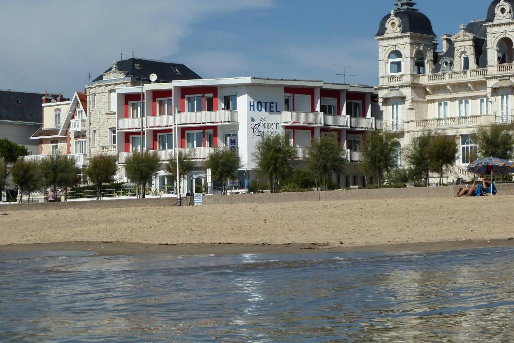 ein Gebäude am Strand neben dem Wasser in der Unterkunft Hotel Le Trident Thyrsé in Royan