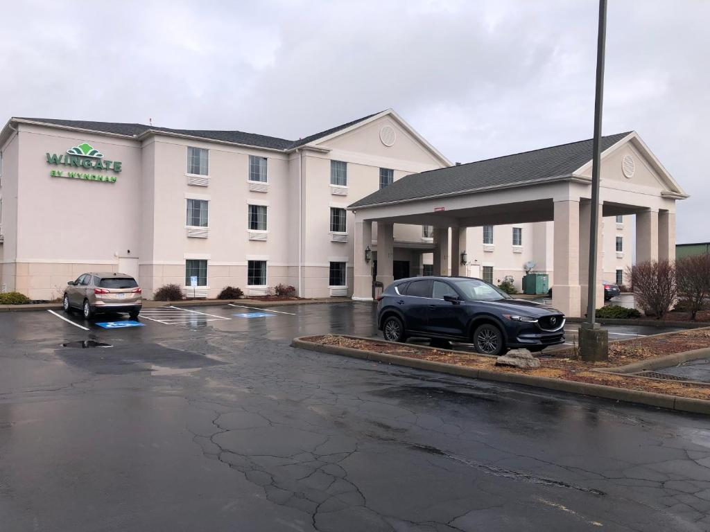 a hotel with a car parked in a parking lot at Wingate by Wyndham Grove City in Grove City