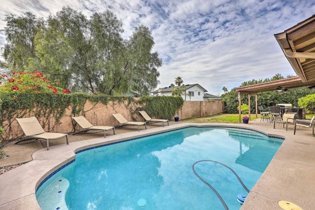 a swimming pool with chairs and a fence at Well-Appointed Glendale Home with Outdoor Pool! in Glendale