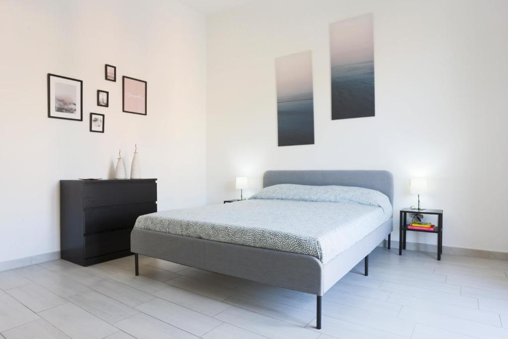 een witte slaapkamer met een bed en een dressoir bij Bright & Central Apartment near the station in Salerno