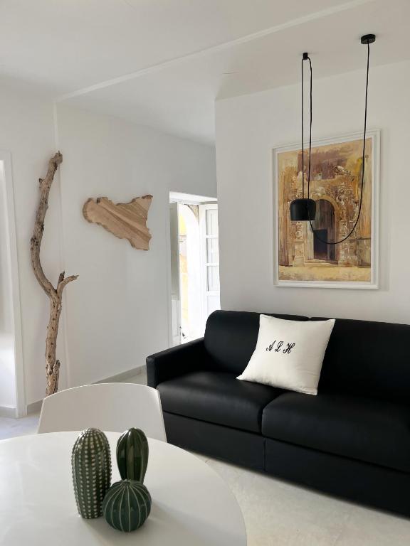 a living room with a black couch and a table at Artemide Luxury Home in Syracuse
