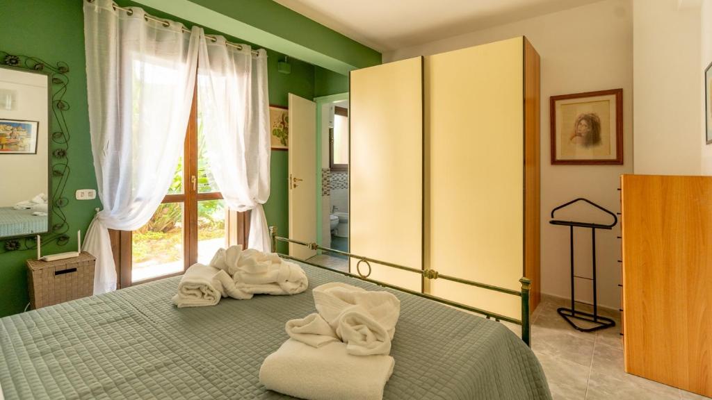 een slaapkamer met een bed met handdoeken erop bij Appartamento Carmi con giardino in Siracusa