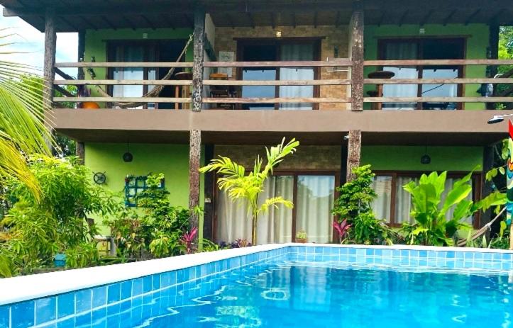 una casa con piscina frente a una casa en Carpe Diem Suítes Taipu de Fora, en Maraú