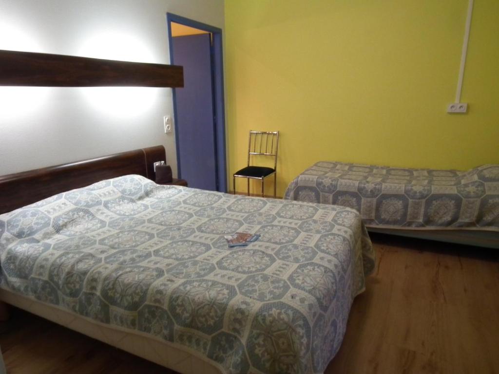 Rúm í herbergi á Friendly Auberge