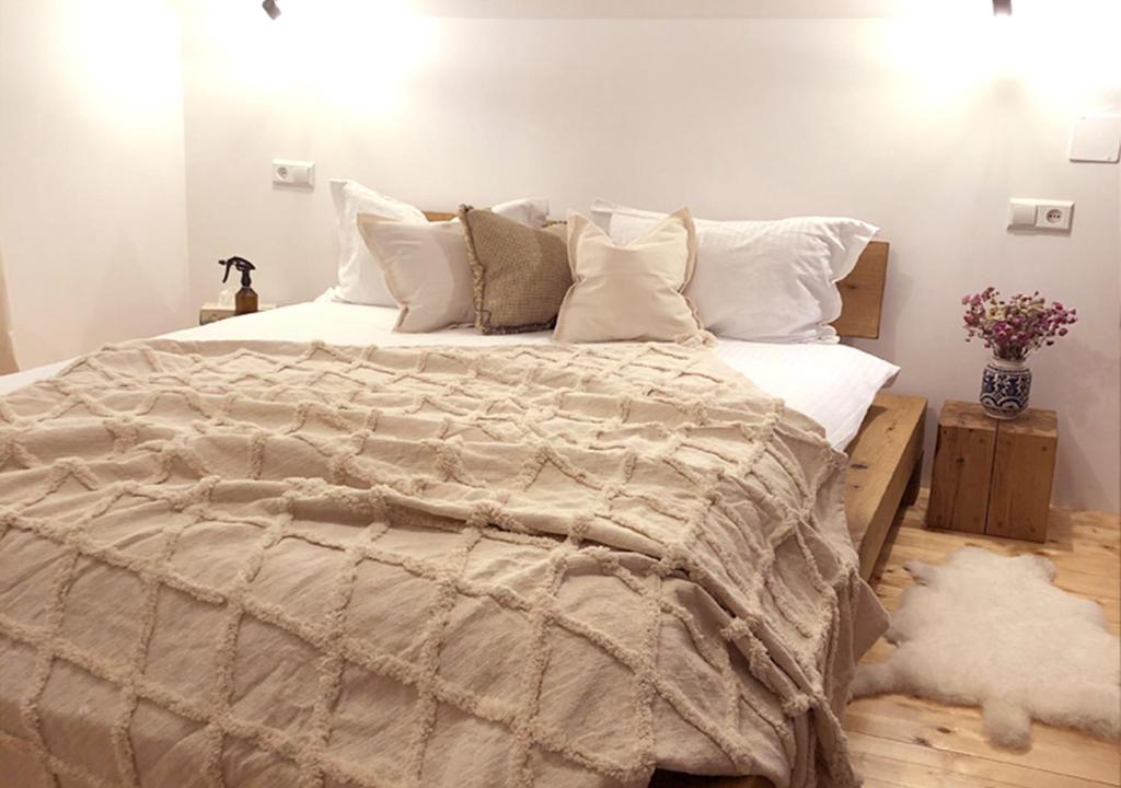 una camera da letto con un grande letto con lenzuola e cuscini bianchi di Cabana Wonderland a Păuliş