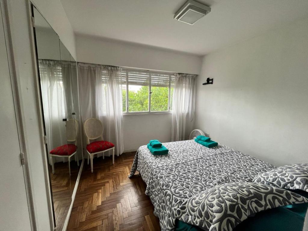 1 dormitorio con cama, ventana y espejo en Mira Bosques en La Plata