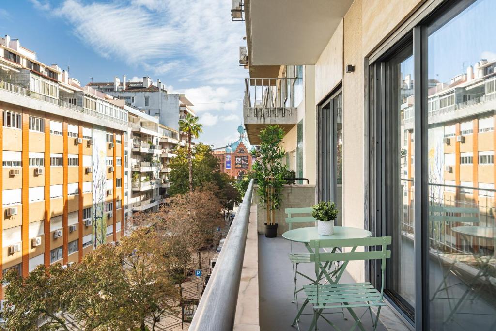 een balkon met een tafel en stoelen en gebouwen bij Succeed Campo Pequeno Apartments in Lissabon