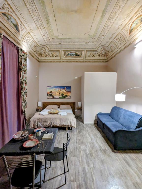salon z łóżkiem i niebieską kanapą w obiekcie B&B Benincasa w mieście Palermo